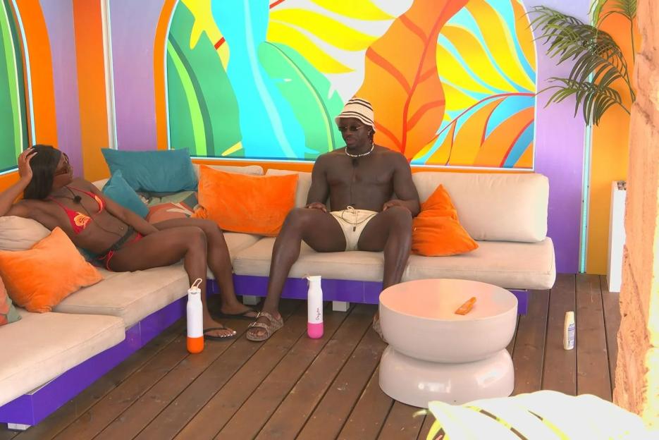 Two Love Island contestants talking on a patio.