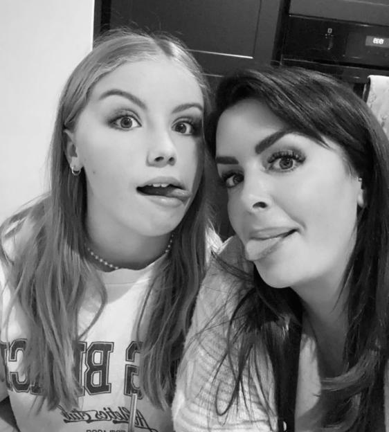 Black and white photo of a mother and daughter sticking their tongues out.
