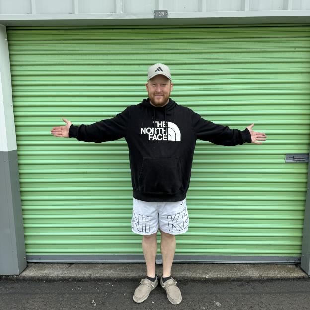 Man standing in front of a green storage unit.
