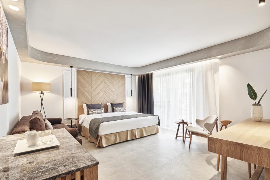 Hotel room with king-size bed and sitting area.