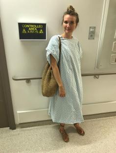 Woman in hospital gown awaiting X-ray.