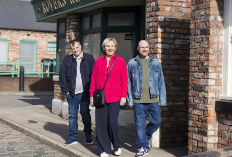 Three actors from Coronation Street outside the Rovers Return.