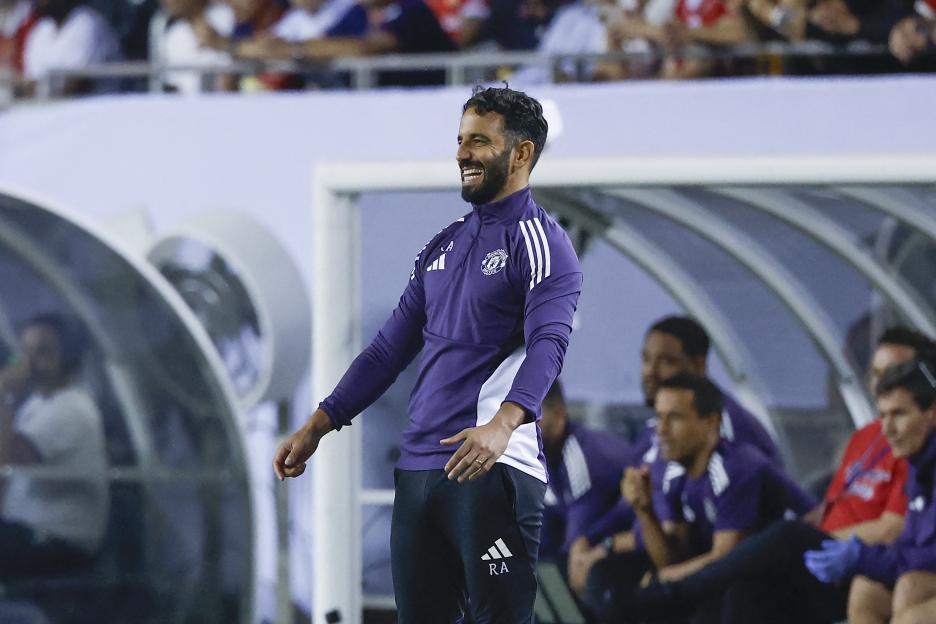 Ruben Amorim, Manchester United coach, smiling on the sidelines.