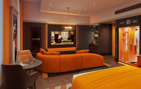 Illustration of a Hilton hotel suite featuring McLaren F1 simulators, a bar, and orange decor.