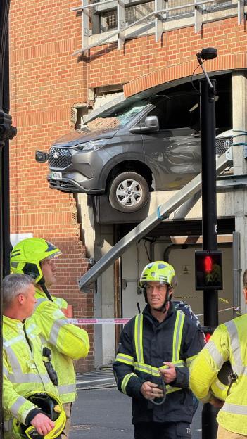 Car crashes through multi-story car park, injuring pedestrians.