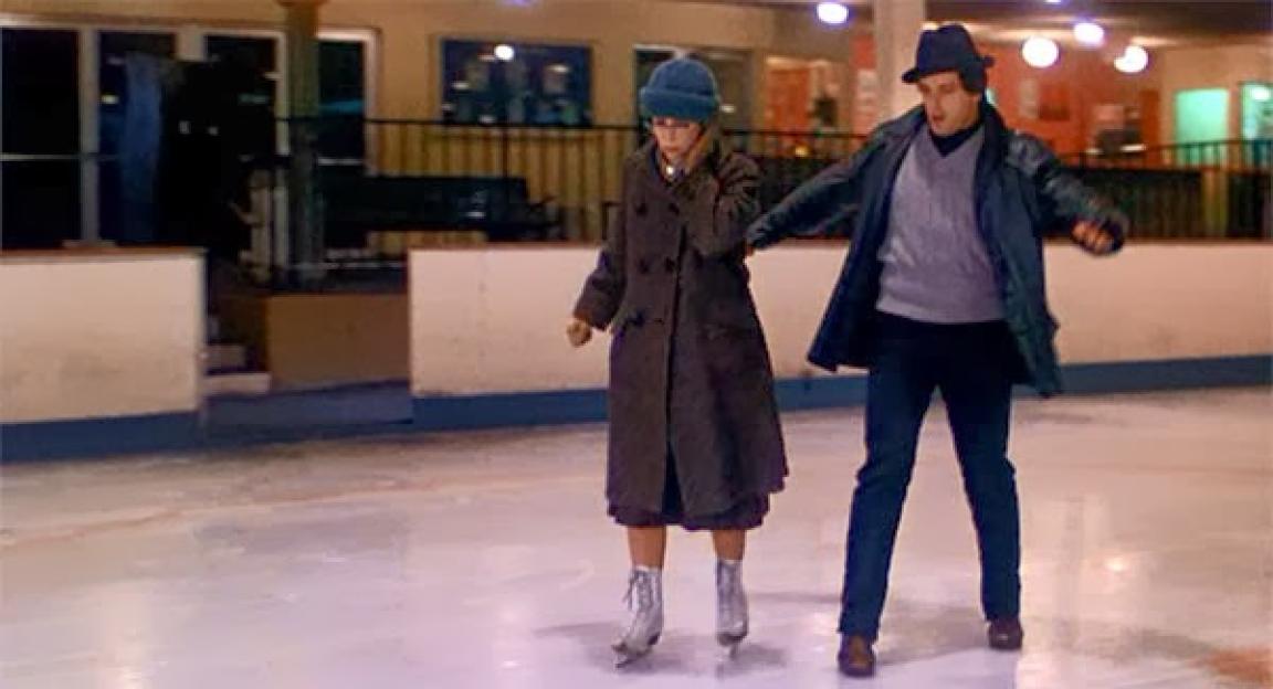 A man and woman ice skating.