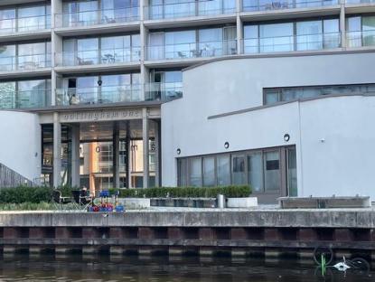Nottingham One building entrance with seating area and canal view.