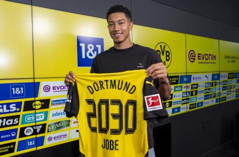 Jobe Bellingham holding a Borussia Dortmund jersey.