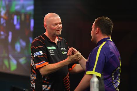 Raymond van Barneveld and Luke Littler shaking hands before a darts match.
