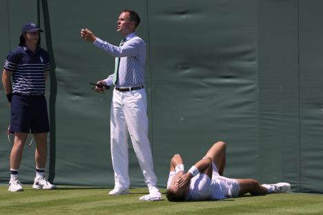 Hamad Medjedovic of Serbia lies injured on a tennis court.