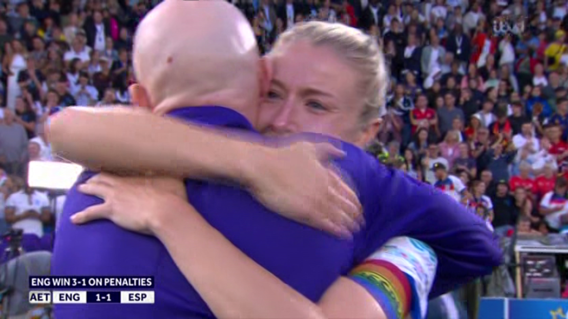 Two women embracing after a soccer game win.