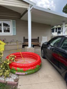 Strawberry-shaped inflatable pool blocking driveway.