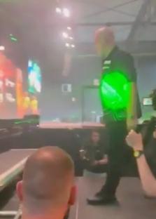 Man standing on stage in front of a screen.