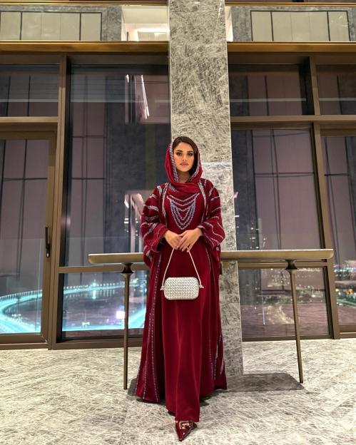Woman in a red abaya and headscarf.