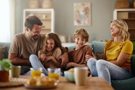 Happy family laughing together on a couch.