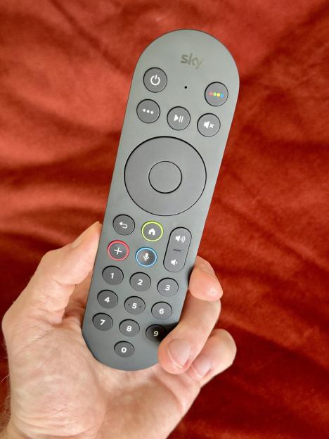 Hand holding a Sky remote control.