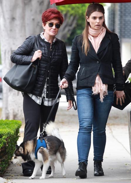 Sharon and Aimee Osbourne walking a dog.