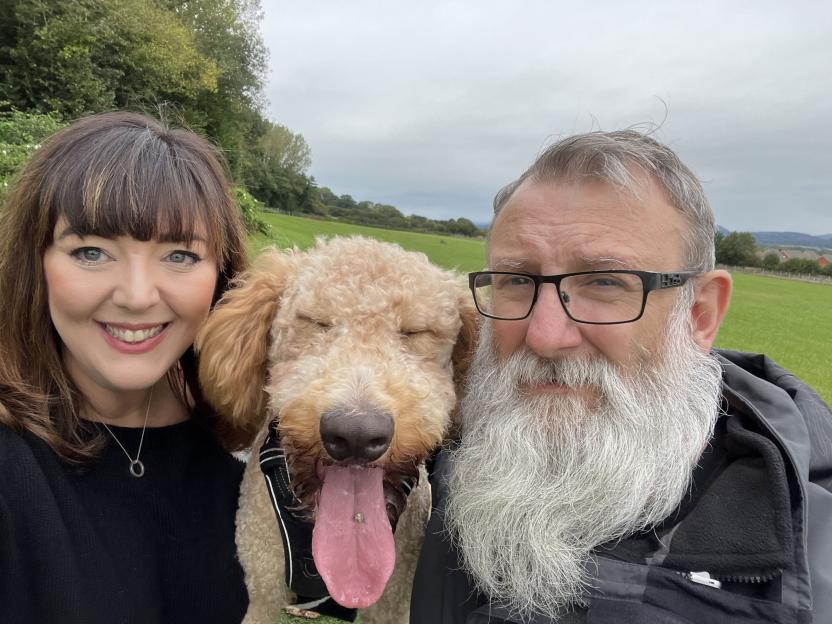 A couple and their large Bernedoodle dog.