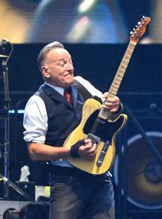 Bruce Springsteen playing guitar on stage.