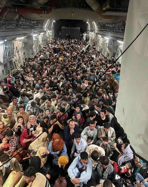 Crowded airplane cabin filled with Afghan refugees.