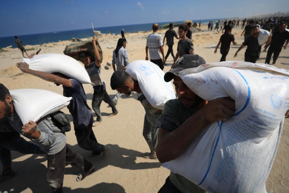 Palestinians carrying aid near Sudaniyyah.