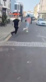 Two people running down a street.