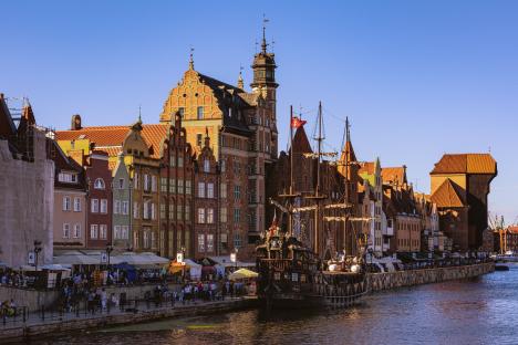 Gdansk's riverside with medieval buildings and a ship.