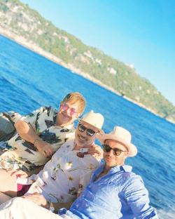 Elton John, David Furnish, and David Beckham on a boat.