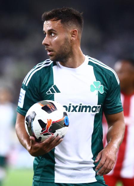 Panathinaikos player George Baldock holding a soccer ball.