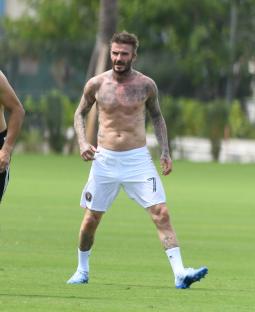 David Beckham shirtless on a soccer field.