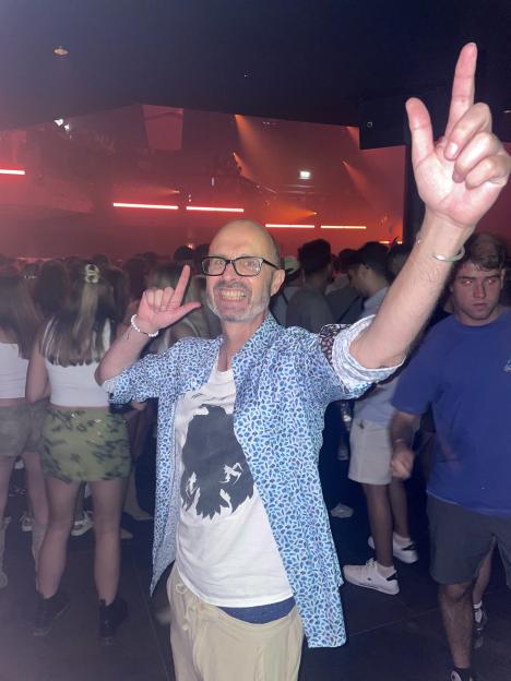 Man in a nightclub making hand gestures.