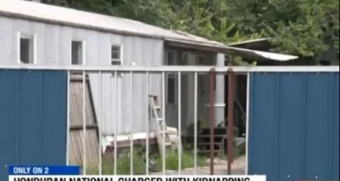 Mobile home behind a fence; kidnapping scene.
