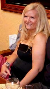 Woman in black strapless dress smiling.