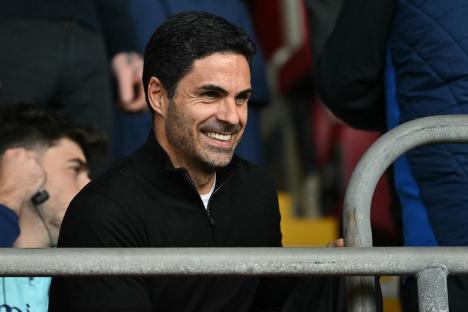 Mikel Arteta, Arsenal's manager, smiling at a football match.