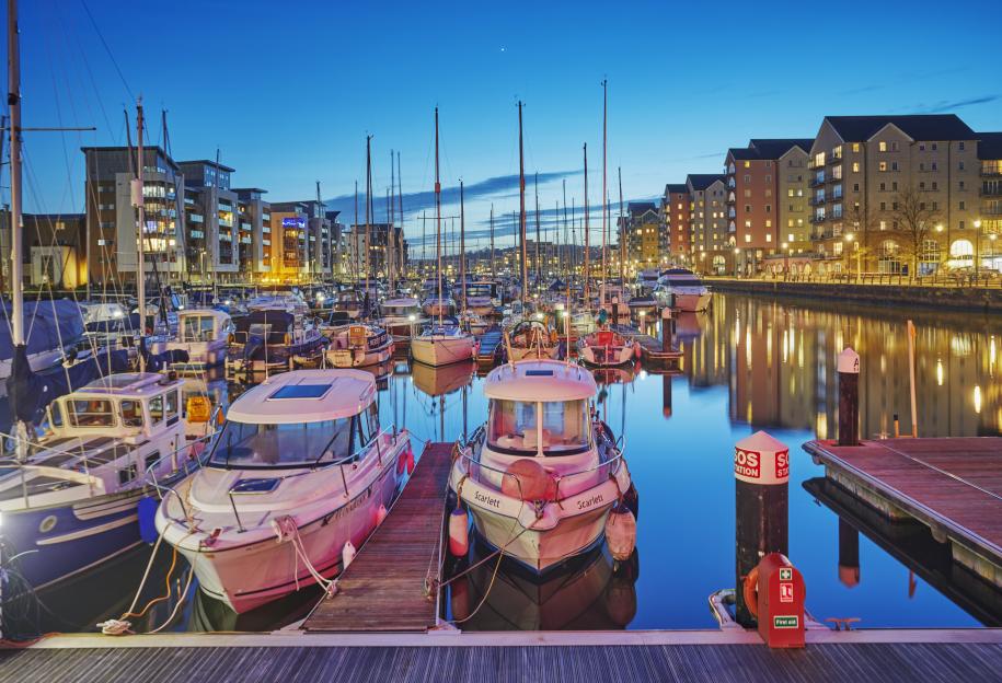 Marina at dusk with boats docked.