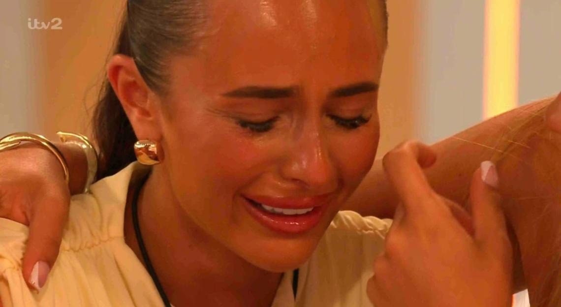 A woman crying, comforted by another woman.