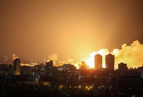 Fire and smoke rising over a city at night after a drone strike.