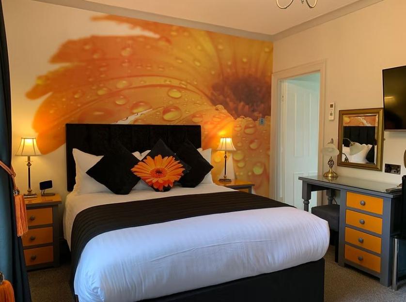 Hotel bedroom with orange flower mural.