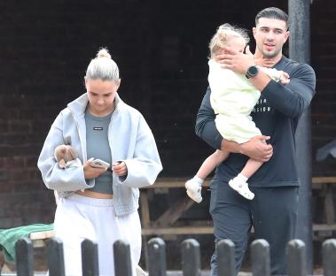 Molly Mae Hague and Tommy Fury walking with their daughter.