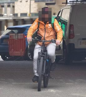 Migrant food delivery cyclist returning his bike.