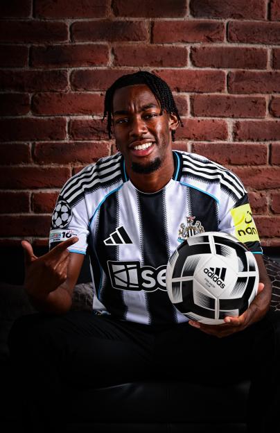 Anthony Elanga in Newcastle United jersey holding a soccer ball.