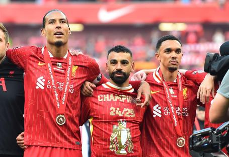 Liverpool players Virgil van Dijk, Mohamed Salah, and Trent Alexander-Arnold with Premier League winner's medals.