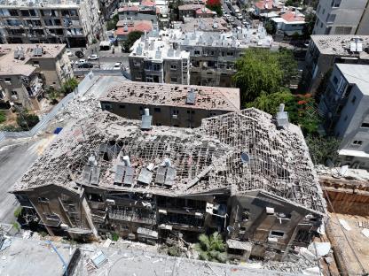 Aerial view of a building damaged by a missile strike.