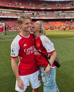 Martin Odegaard and his girlfriend at a soccer stadium.