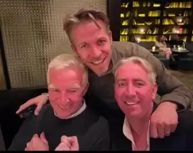 Three men posing for a photo together.