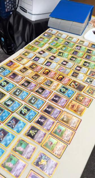 A table covered in numerous rare Pokémon trading cards.