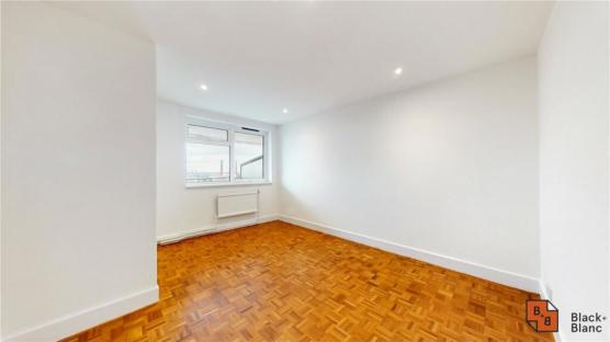 Empty room with hardwood floors and a window.