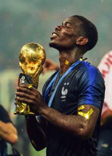 Paul Pogba holding the World Cup trophy.