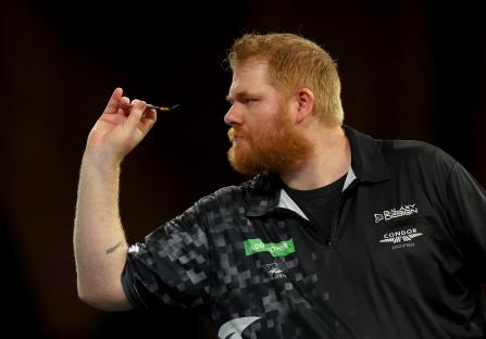 Matt Campbell throwing a dart during a darts match.
