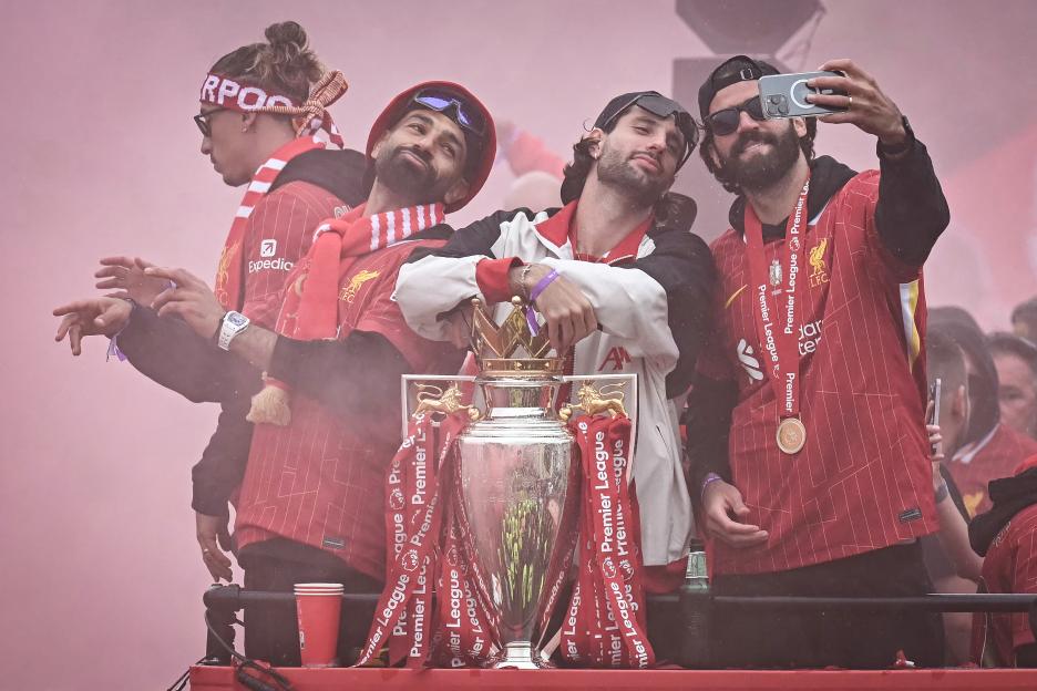Liverpool players celebrating with the Premier League trophy.